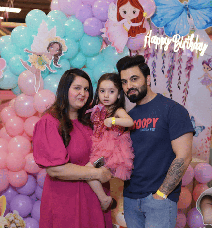 Family celebrating a child's birthday at Mio Wooray with colourful balloon decorations and a unicorn-themed backdrop.