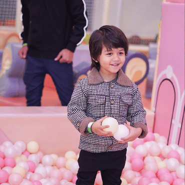 Child enjoying colourful ball pit play at Mio Wooray indoor play area.