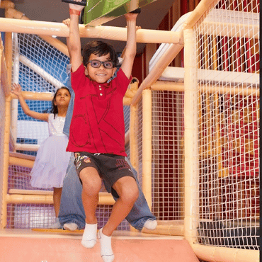 Child enjoying an indoor climbing and adventure activity at Mio Wooray.